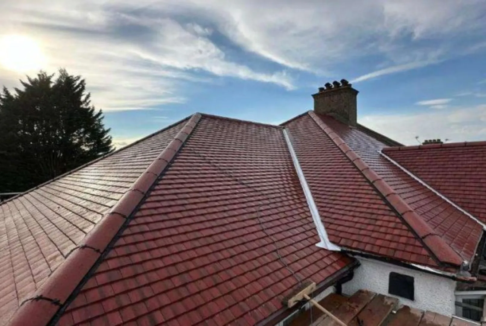 Completed red tile roof with new ridge and chimney flashing by Phoenix Roofing