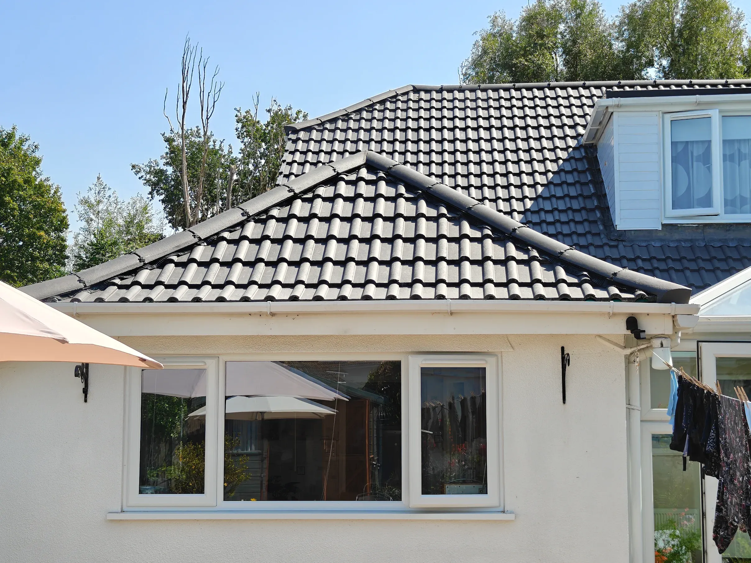 Customer photo: completed hip-roof retile on a white bungalow by Phoenix Roofing